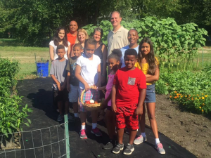 Multiple students stand with Middle Township Mayor in CCWI garden.